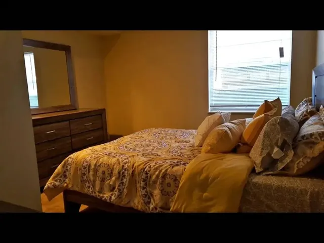 a bed sitting in a bedroom next to a window