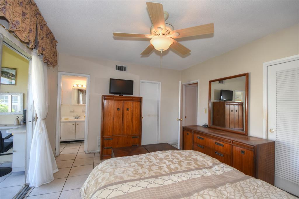 1951 Northeast 39th Street, Unit 360 Lighthouse Point, FL 33064 - Photo 13 of 28 a bedroom with a bed and a flat screen tv
