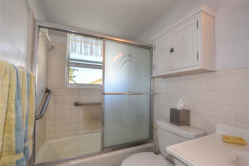 1951 Northeast 39th Street, Unit 360 Lighthouse Point, FL 33064 - Photo 16 of 28 a bathroom with a shower and a toilet