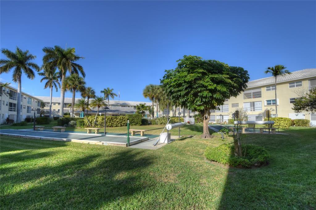 1951 Northeast 39th Street, Unit 360 Lighthouse Point, FL 33064 - Photo 25 of 28 a view of a swimming pool with a table and chairs