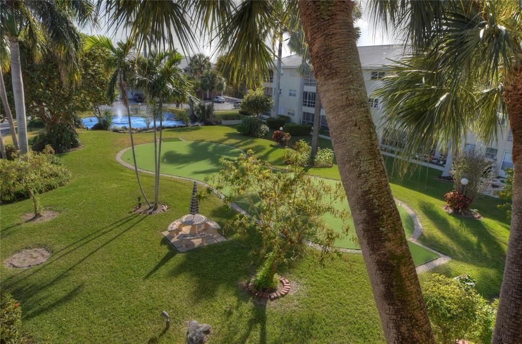 1951 Northeast 39th Street, Unit 360 Lighthouse Point, FL 33064 - Photo 27 of 28 a backyard of a house with a garden and outdoor seating