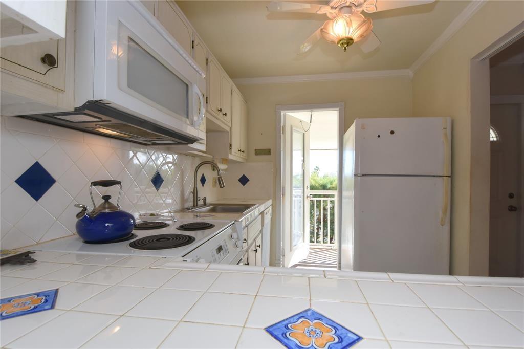 1951 Northeast 39th Street, Unit 360 Lighthouse Point, FL 33064 - Photo 4 of 28 a kitchen with stainless steel appliances granite countertop a sink a stove and a refrigerator