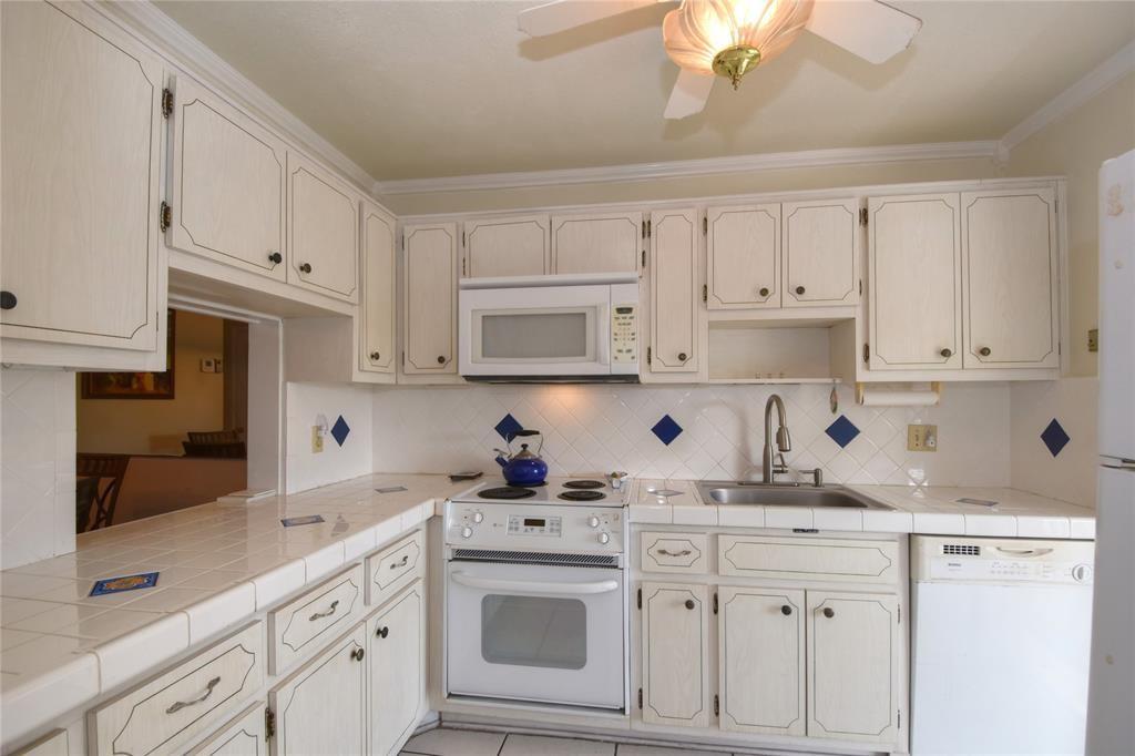 1951 Northeast 39th Street, Unit 360 Lighthouse Point, FL 33064 - Photo 6 of 28 a kitchen with white cabinets and white appliances