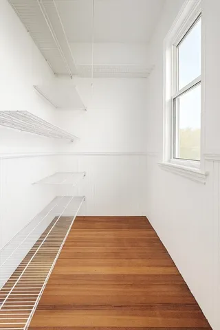a view of a room with wooden floor and windows