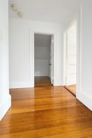 a view of an empty room with closet and bathroom