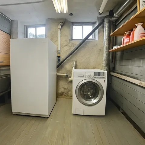 a utility room with wooden floor washer and dryer