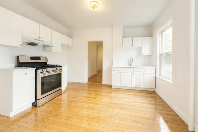 a kitchen with granite countertop a stove top oven and cabinets