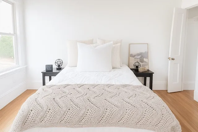 a bed sitting in a bedroom and a large window