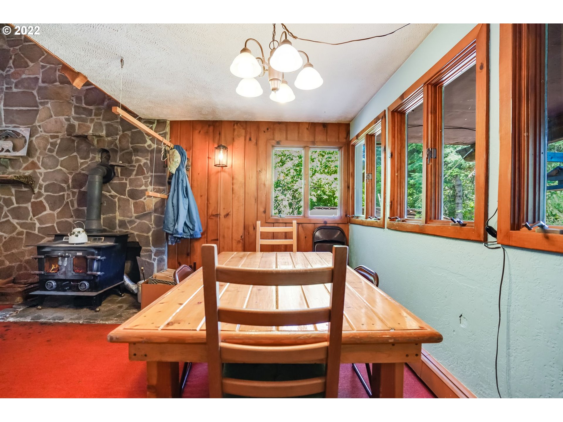 277 Trout Lake Creek Road Trout Lake, WA 98650 - Photo 22 of 35 a view of a dining room with furniture a chandelier and a large window