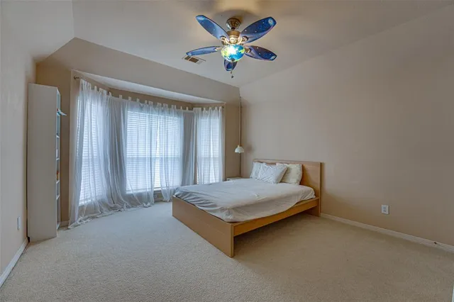 a bedroom with a bed and a ceiling fan