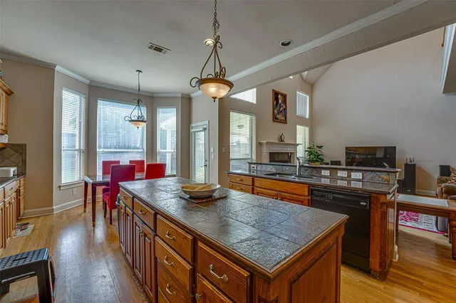 a kitchen with stainless steel appliances granite countertop a kitchen island a stove and a wooden floors