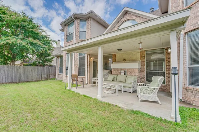 a view of a patio with table and chairs and wooden fence