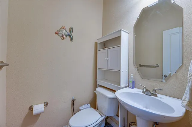 a bathroom with a toilet sink and mirror