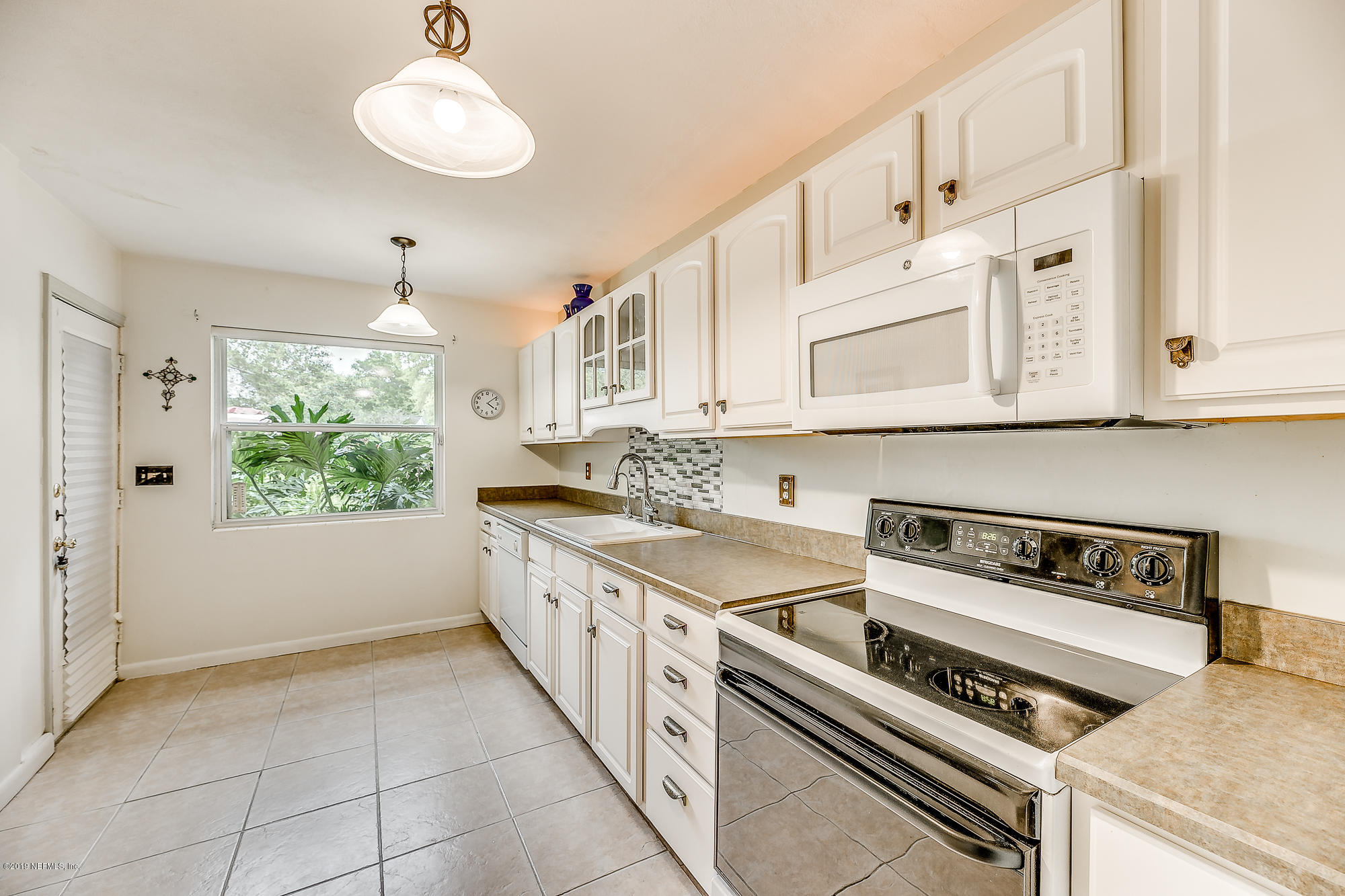 6403 Wesleyan Road Jacksonville, FL 32217 - Photo 25 of 37 a kitchen with stainless steel appliances a white cabinets and a stove top oven