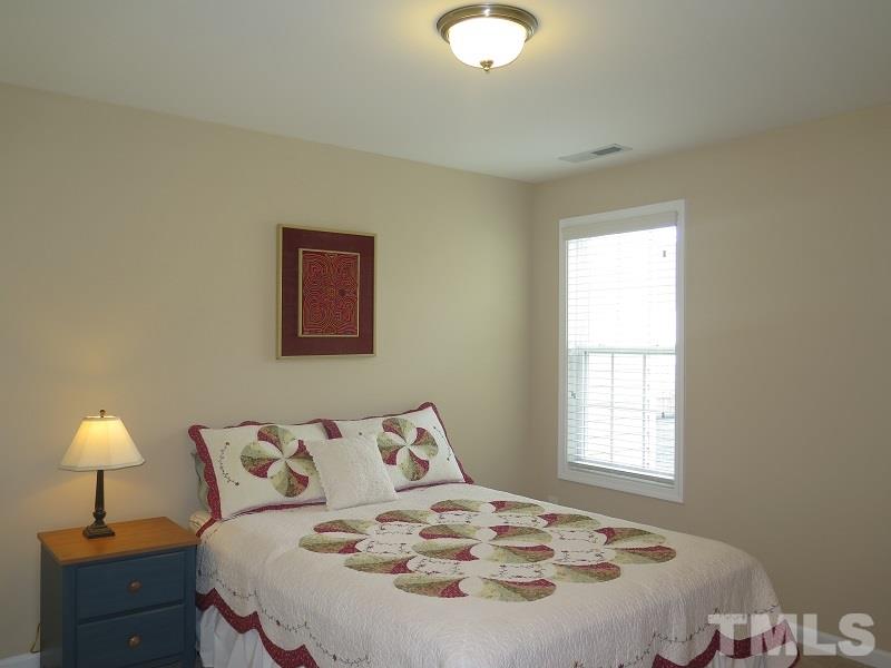 1314 Regulator Street Raleigh, NC 27603 - Photo 16 of 22 a bedroom with a bed and a lamp