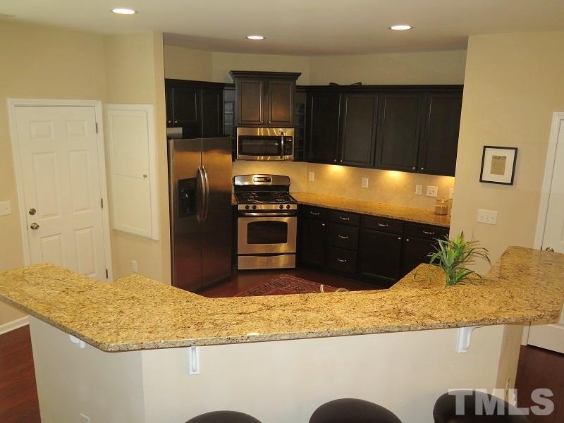 1314 Regulator Street Raleigh, NC 27603 - Photo 7 of 22 a kitchen with stainless steel appliances granite countertop a sink and a stove