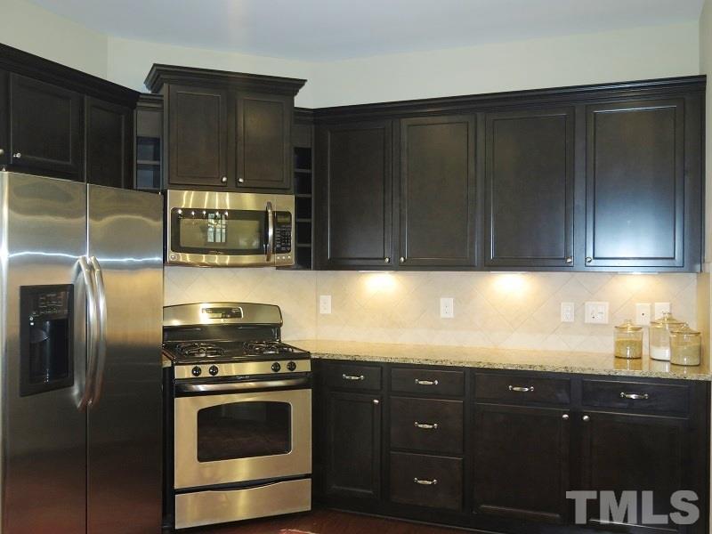 1314 Regulator Street Raleigh, NC 27603 - Photo 8 of 22 a kitchen with granite countertop stainless steel appliances wooden cabinets and a sink