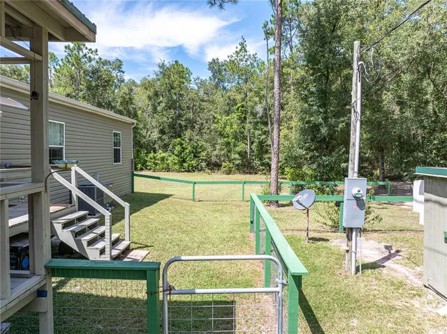 a view of a park with large trees and slide