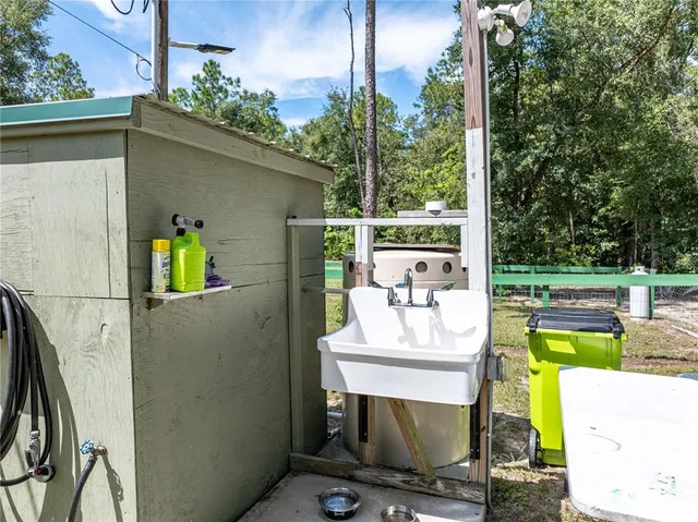 a view of a backyard with large trees and wooden fence