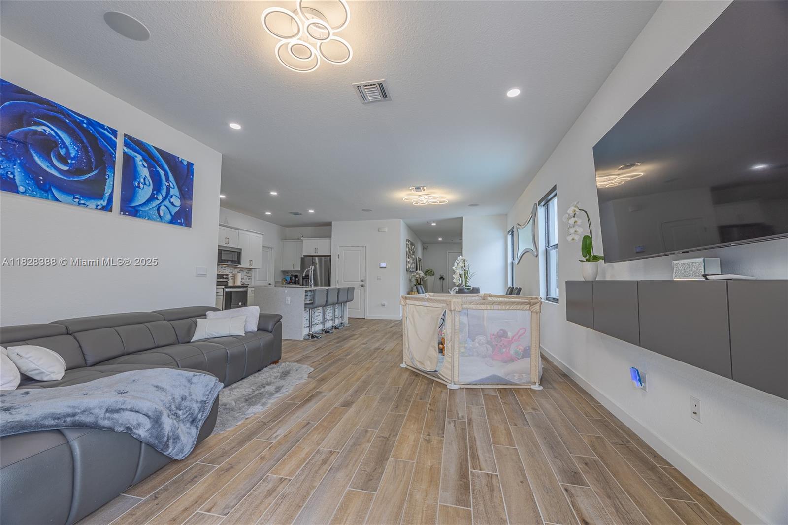 7126 Rockwood Road Jupiter, FL 33458 - Photo 13 of 30 a large white kitchen with wooden floors and stainless steel appliances