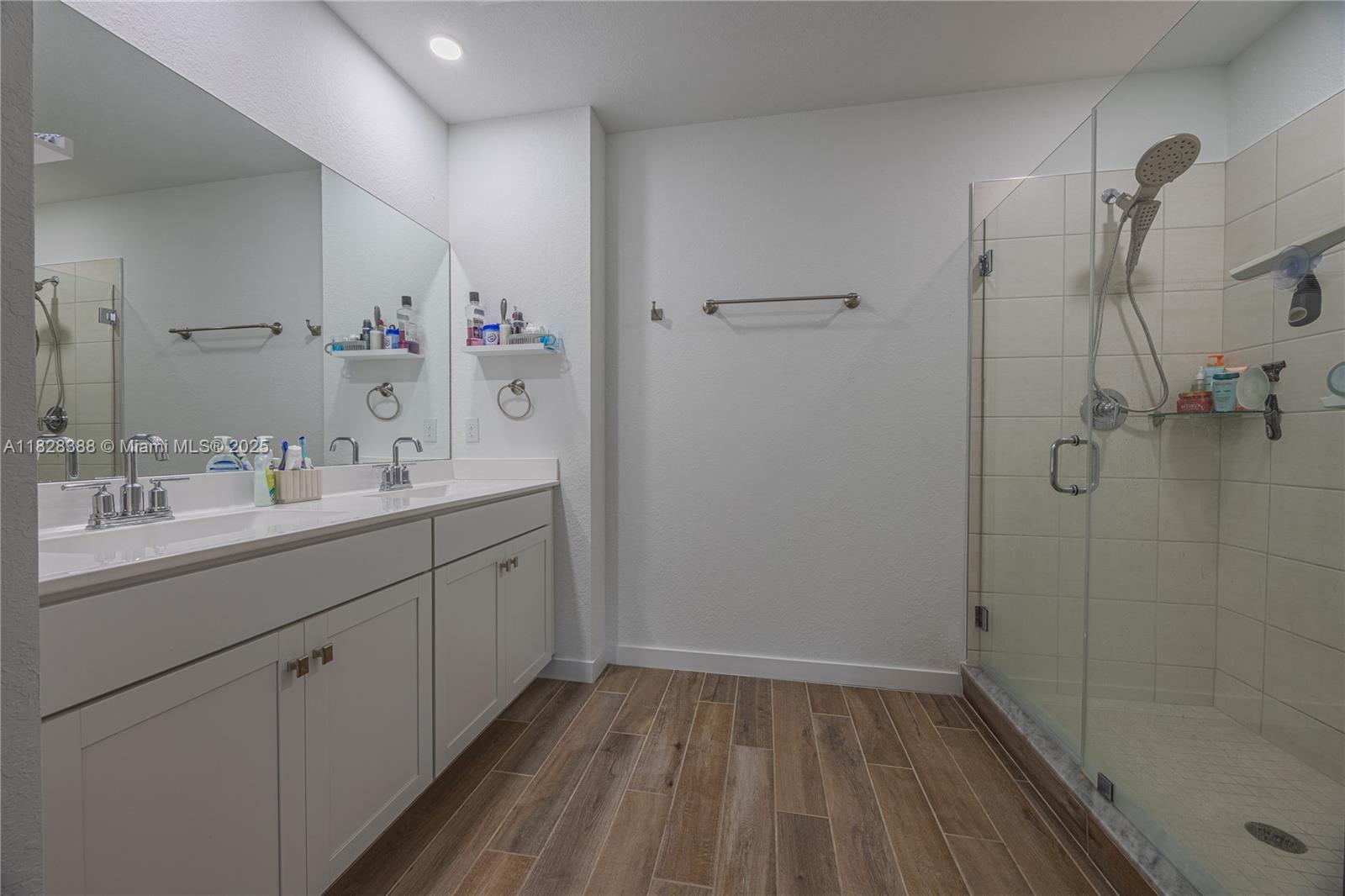7126 Rockwood Road Jupiter, FL 33458 - Photo 23 of 30 a spacious bathroom with a double vanity sink a mirror and a shower