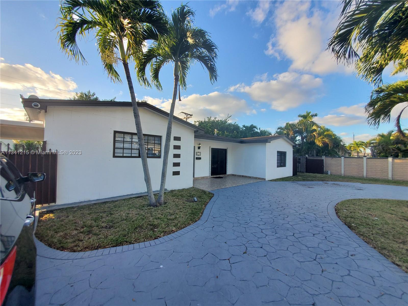 2120 Southwest 84th Avenue Miami, FL 33155 - Photo 1 of 8 a view of a house with a yard potted plants and palm tree