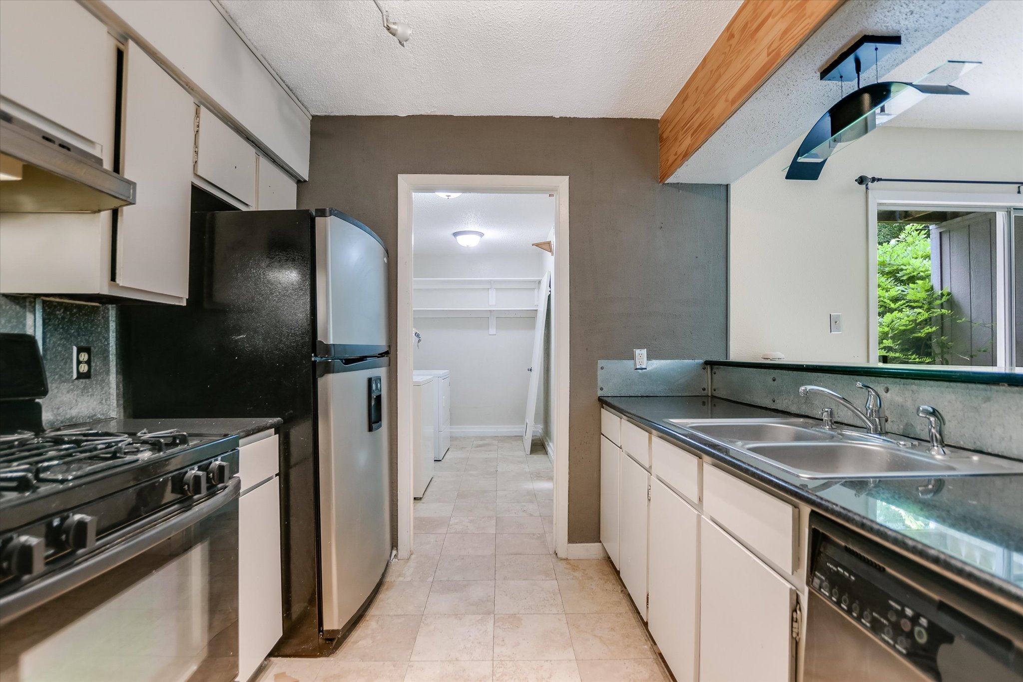 700 Castle Ridge Road, Unit C Austin, TX 78746 - Photo 5 of 10 a kitchen with a sink stove and refrigerator