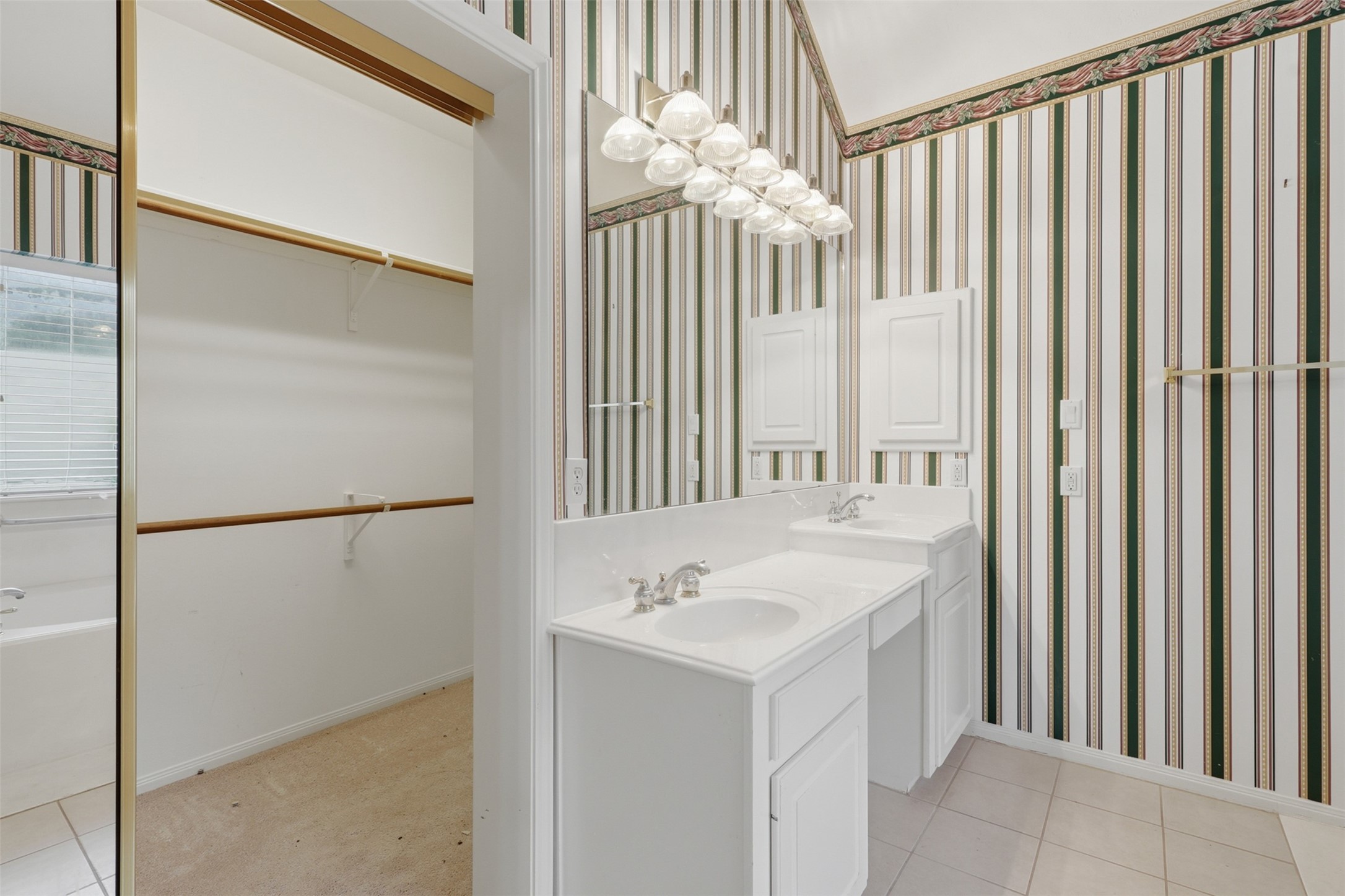 5815 Pheasant Ridge Lane Houston, TX 77041 - Photo 33 of 43 Designed with both luxury and functionality in mind, the primary bathroom features his-and-her vanities with raised and seated-height countertops, a dedicated makeup area, a convenient medicine cabinet, and an outstanding oversized walk-in closet with abundant storage. Every detail has been thoughtfully designed for comfort and everyday living.