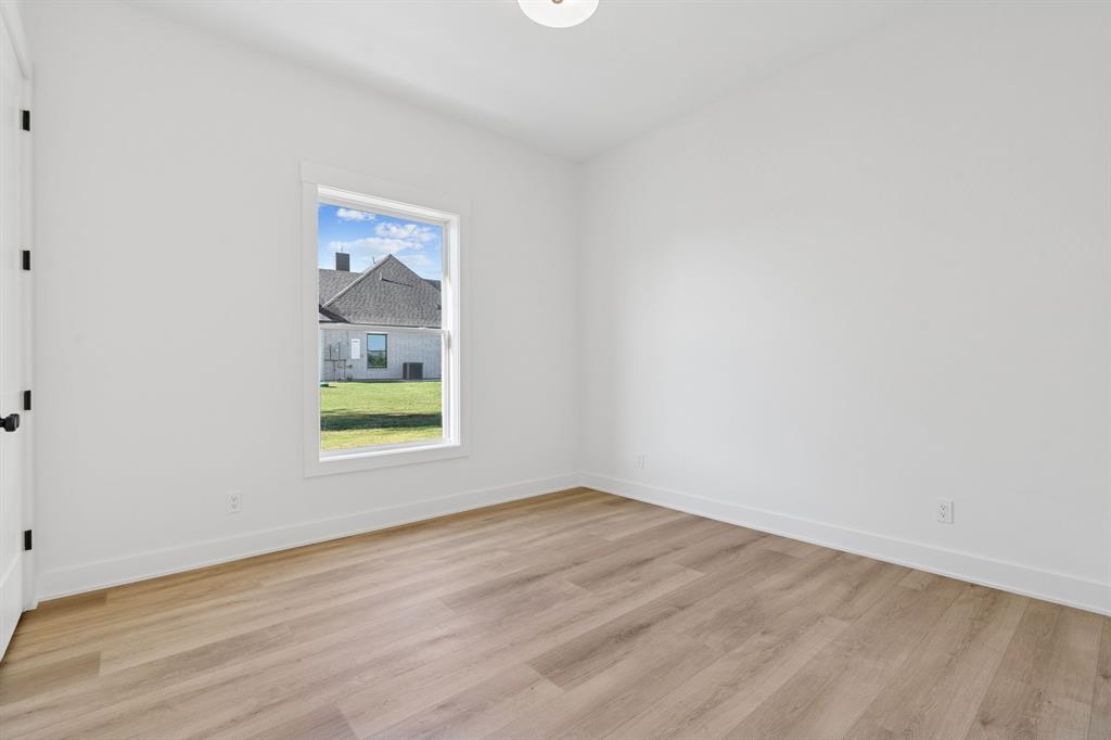 8008 Ben Day Murrin Road Fort Worth, TX 76126 - Photo 27 of 40 a view of an empty room with wooden floor and a window