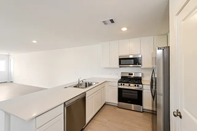 a kitchen with stainless steel appliances a stove microwave and refrigerator