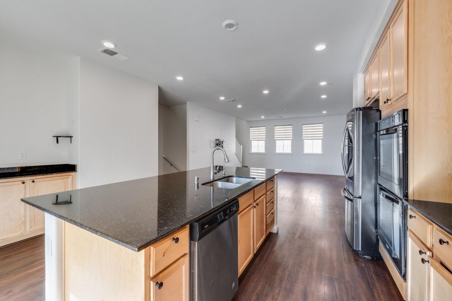 6914 Geyserville Street Dublin, CA 94568 - Photo 13 of 43 a kitchen with counter top space cabinets and wooden floor