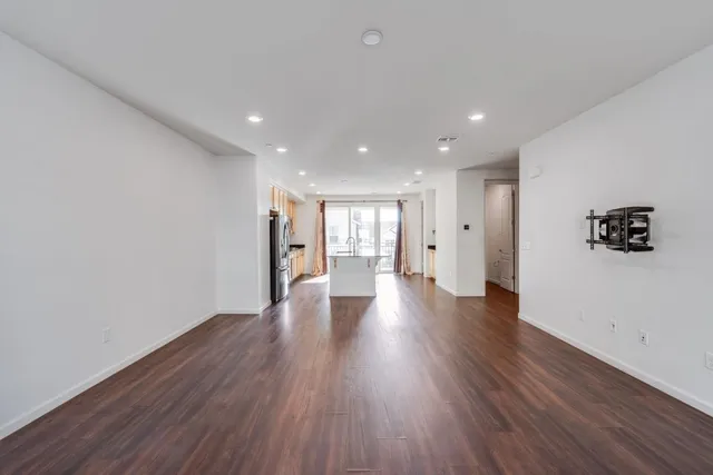 a view of a big room with wooden floor and windows