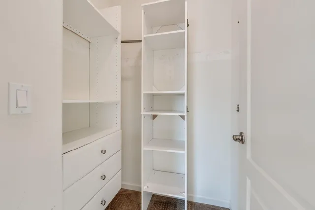 a bathroom with a closet and mirror