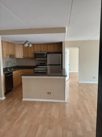 a kitchen with kitchen island a sink a stove and cabinets