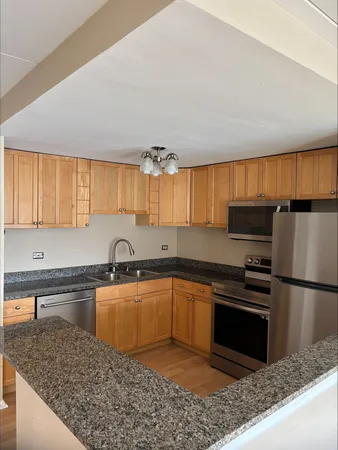a kitchen with granite countertop a sink stainless steel appliances and cabinets