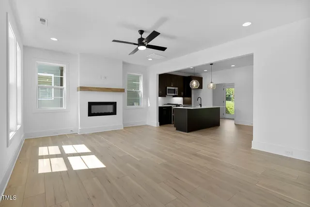 wooden floor fireplace and windows in an empty room