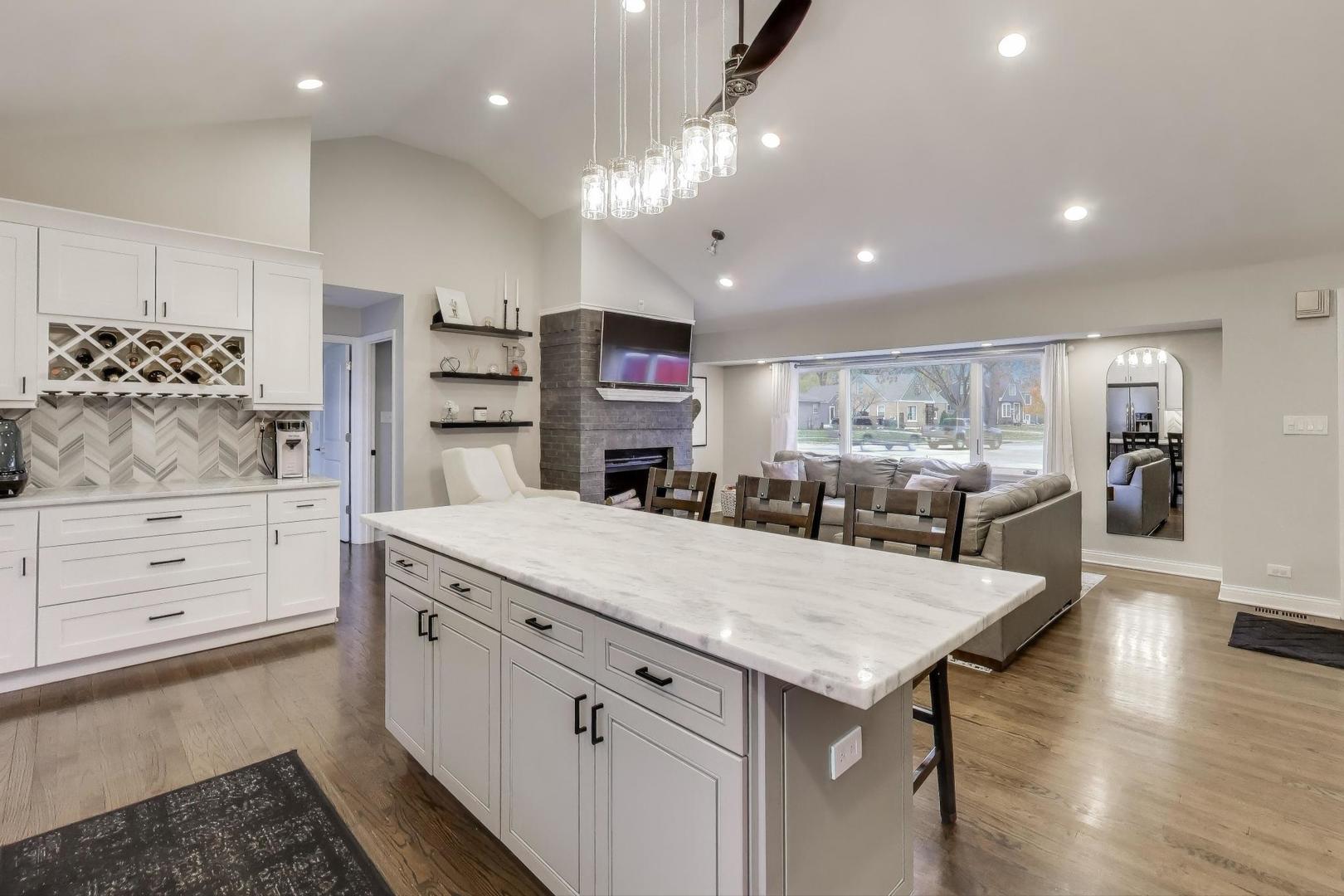 591 South Park Road Lombard, IL 60148 - Photo 3 of 30 a kitchen with stainless steel appliances kitchen island granite countertop a table and chairs in it