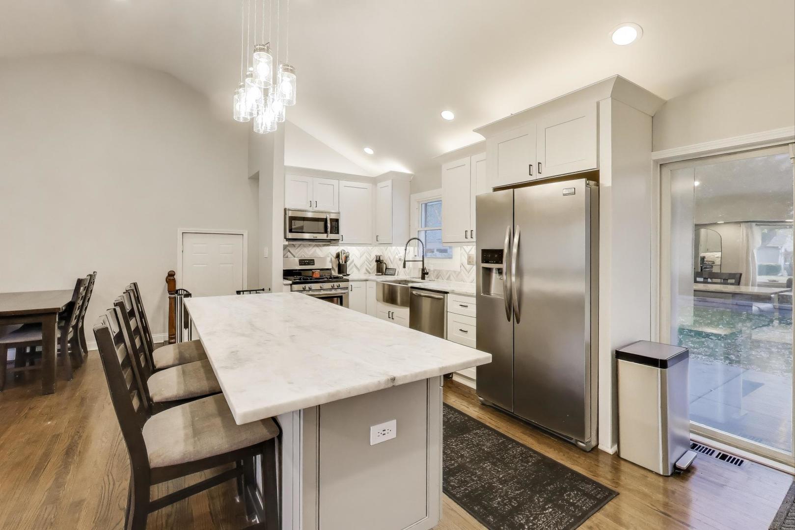 591 South Park Road Lombard, IL 60148 - Photo 10 of 30 a kitchen with stainless steel appliances a refrigerator a stove a dining table and chairs