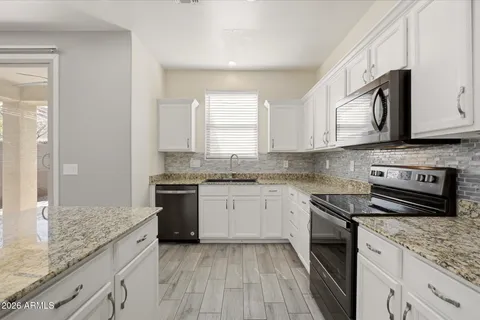 a kitchen with stainless steel appliances granite countertop a stove sink and cabinets