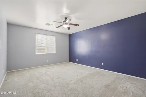 an empty room with windows and fan