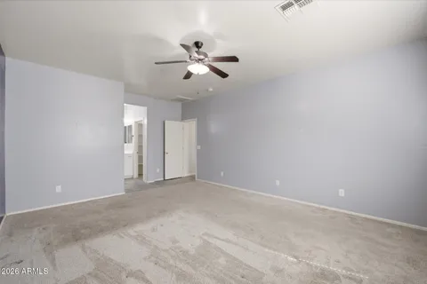 an empty room with windows and fan