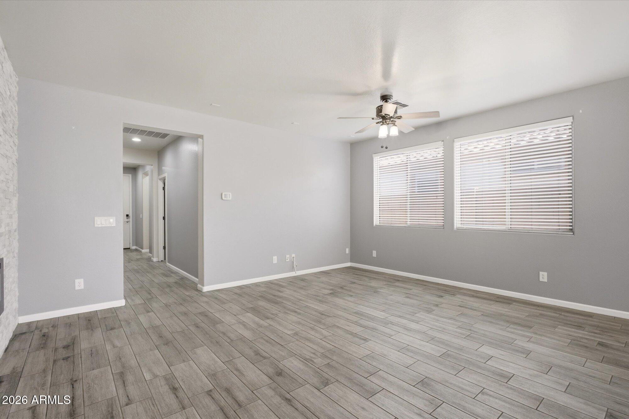 3347 East Roland Street Mesa, AZ 85213 - Photo 2 of 25 wooden floor in an empty room with a window