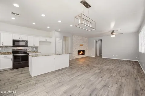 a large kitchen with stainless steel appliances granite countertop a large counter top and oven a sink with wooden floor