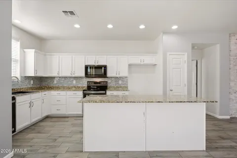 a kitchen with granite countertop cabinets stainless steel appliances and a sink