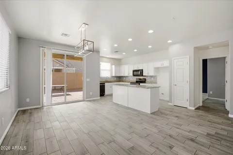 a view of kitchen with granite countertop cabinets and refrigerator