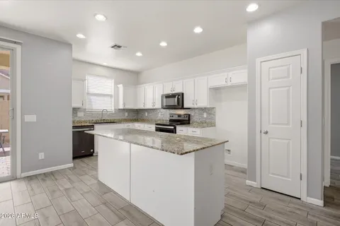a kitchen with stainless steel appliances granite countertop a stove a sink and a refrigerator