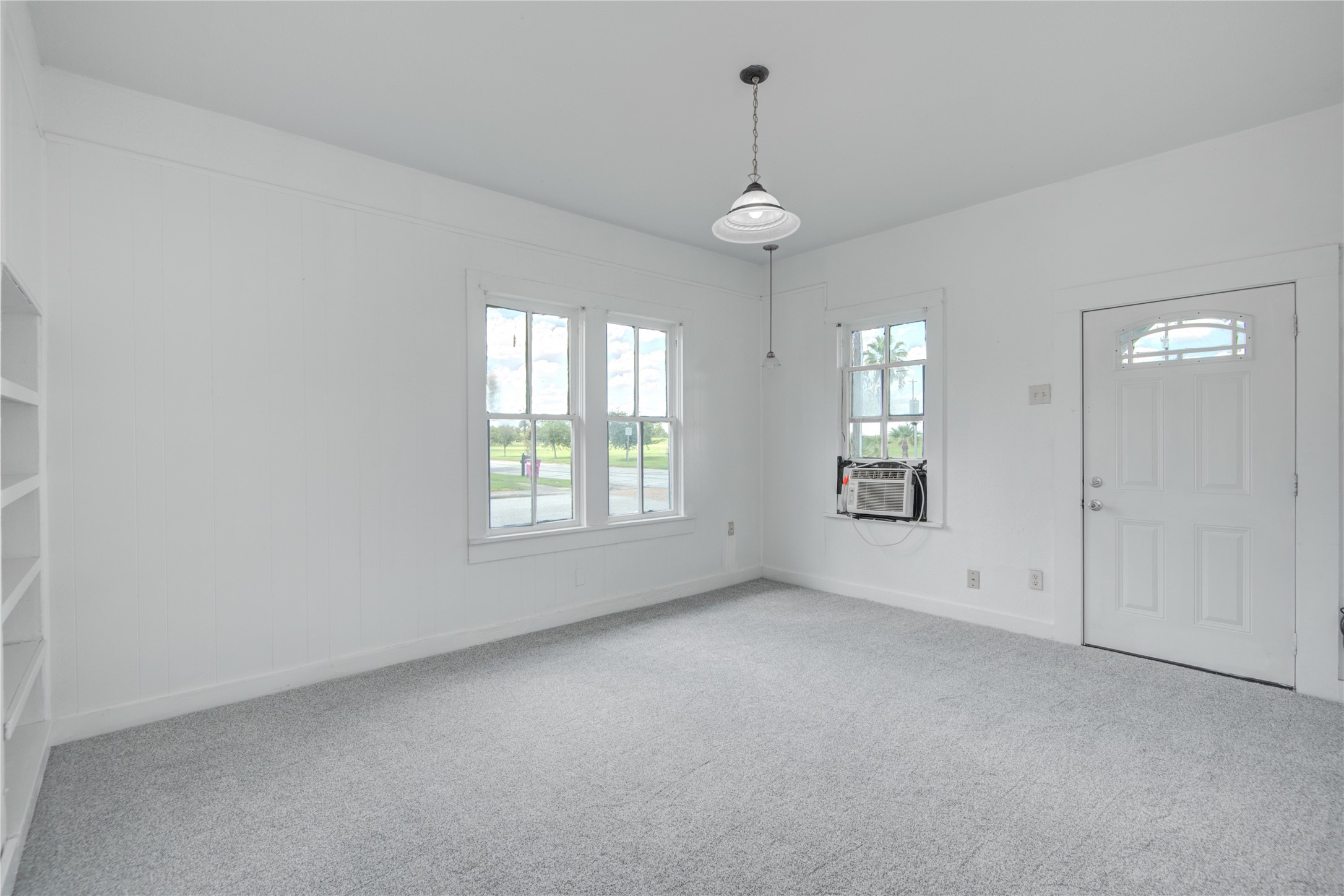 1131 West 2nd Street Freeport, TX 77541 - Photo 21 of 30 an empty room with windows and chandelier fan