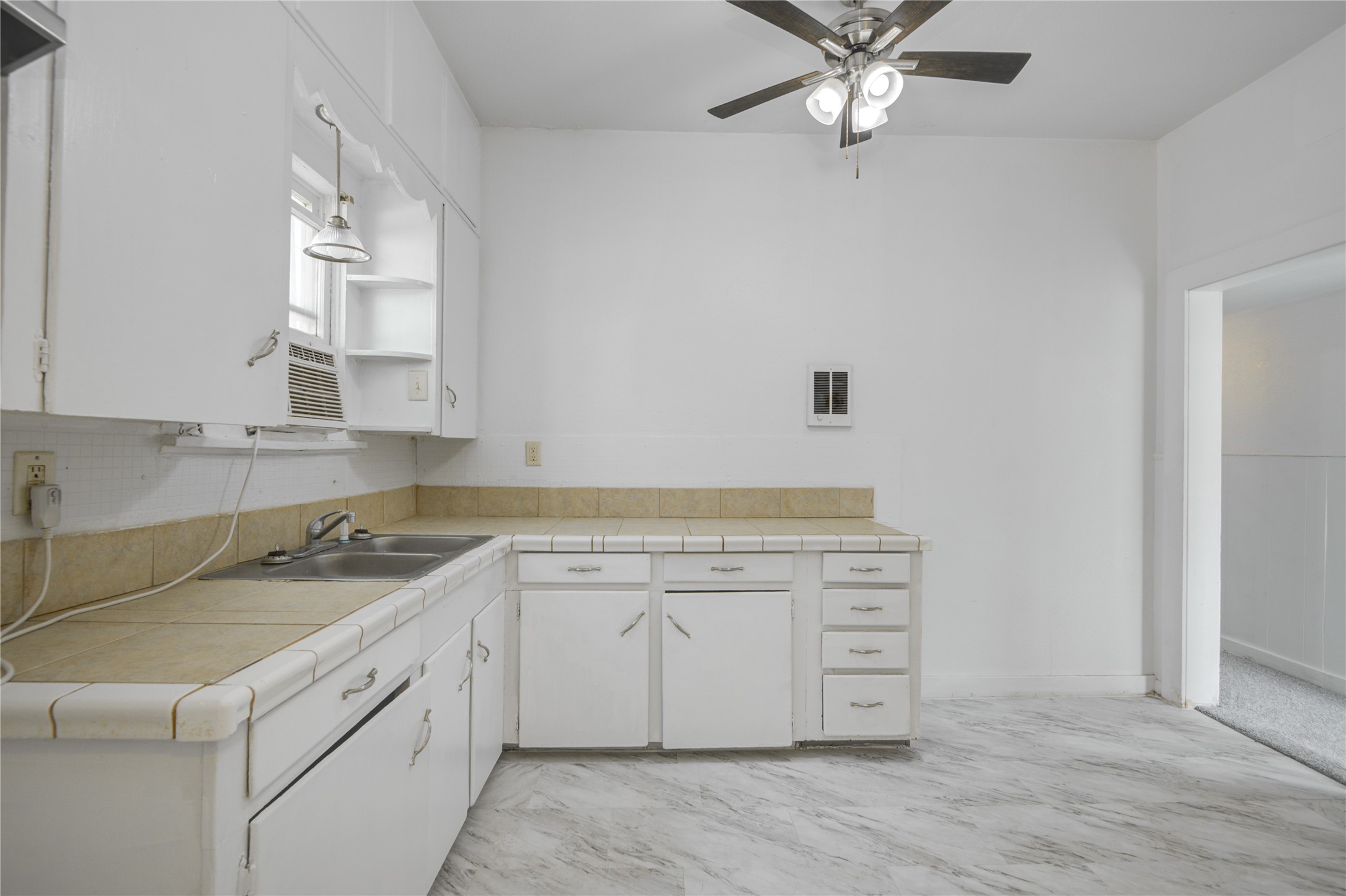 1131 West 2nd Street Freeport, TX 77541 - Photo 23 of 30 a kitchen with a sink dishwasher a stove and white cabinets with wooden floor