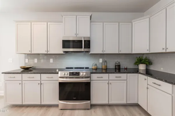 a kitchen with white cabinets and stainless steel appliances