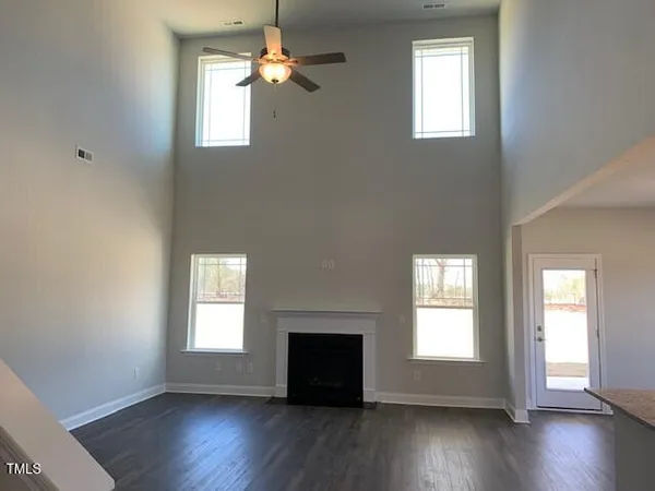 a view of empty room with a fireplace and wooden floor